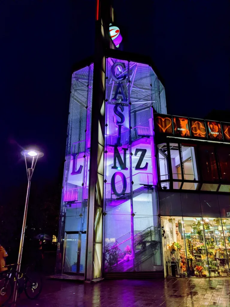 Beleuchteter Eingang des Casino Linz bei Nacht