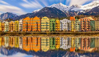 Bunte Häuser am Innufer in Innsbruck vor den Alpen